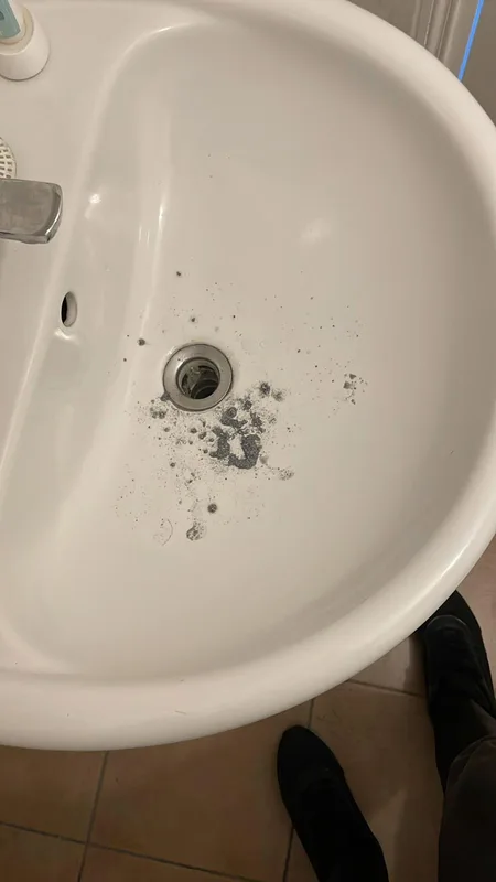 Lavabo avec débris autour de la bonde avant débouchage